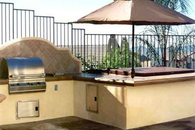 Patio kitchen - mid-sized backyard stone patio kitchen idea in Phoenix