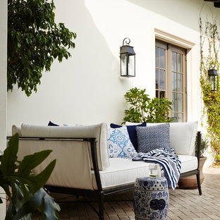 Expansive mediterranean courtyard patio in Miami with a water feature and brick pavers.
