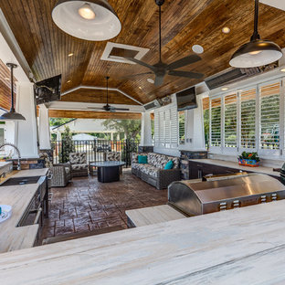 Large coastal back patio in Raleigh with an outdoor kitchen, stamped concrete and a gazebo.