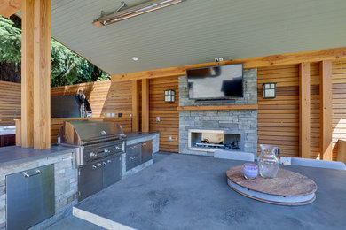 Large minimalist backyard patio photo in Seattle with a fireplace and a gazebo