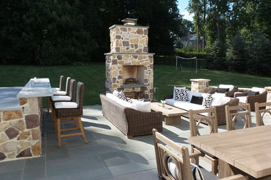 Patio kitchen - large modern backyard stone patio kitchen idea in Philadelphia