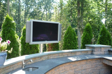 Mid-sized elegant backyard stone patio kitchen photo in Philadelphia with no cover