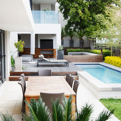 Example of a trendy side yard patio design in Houston with decking and no cover