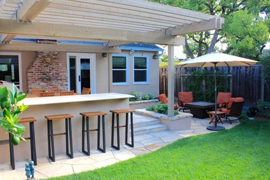 Large arts and crafts backyard stone patio kitchen photo in San Francisco with a pergola