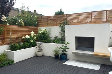 Inspiration for a medium sized contemporary courtyard patio in London with a fire feature, decking and no cover.