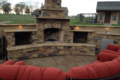 Example of a classic backyard concrete patio design in Kansas City with a fire pit and no cover