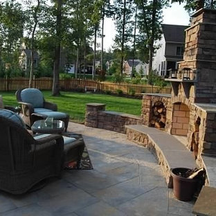 Foto di un patio o portico stile americano di medie dimensioni e dietro casa con un focolare, pavimentazioni in pietra naturale e nessuna copertura