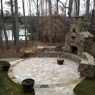 Idee per un grande patio o portico american style in cortile con un focolare, pavimentazioni in pietra naturale e nessuna copertura