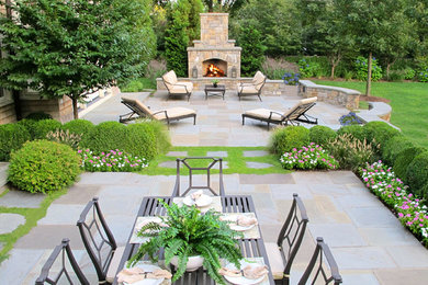 Inspiration for a large contemporary backyard stone patio remodel in New York with a fire pit and no cover