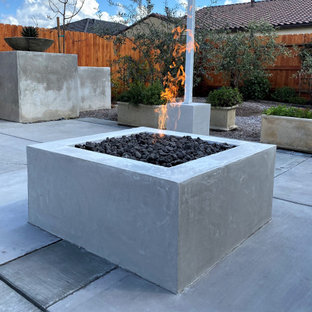 Immagine di un patio o portico american style di medie dimensioni e dietro casa con un caminetto, lastre di cemento e un gazebo o capanno