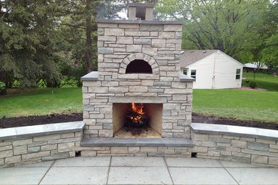 Example of a large classic backyard stone patio kitchen design in Minneapolis