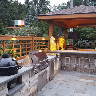 Idee per un grande patio o portico tradizionale dietro casa con pavimentazioni in pietra naturale e un gazebo o capanno