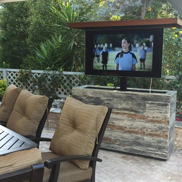 Outdoor hidden TV lift tile and wood island cabinet hides TV and swivels