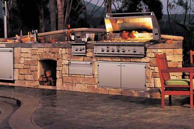 Mid-sized arts and crafts backyard stamped concrete patio kitchen photo with no cover