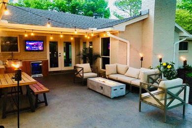 Example of a small trendy backyard concrete patio kitchen design in Dallas with a roof extension