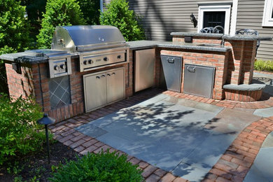 Mid-sized elegant backyard brick patio photo in New York with a fire pit
