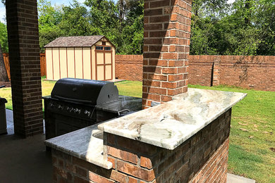 Cette image montre une terrasse arrière traditionnelle de taille moyenne avec une cuisine d'été, une extension de toiture et une dalle de béton.
