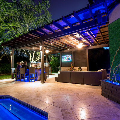 Inspiration for a huge timeless backyard stone patio kitchen remodel in Miami with a pergola