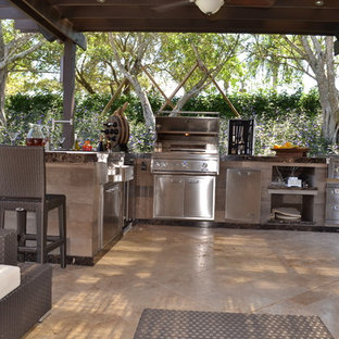 Idee per un ampio patio o portico classico dietro casa con pavimentazioni in pietra naturale e una pergola