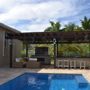 Immagine di un ampio patio o portico mediterraneo dietro casa con pavimentazioni in pietra naturale e una pergola