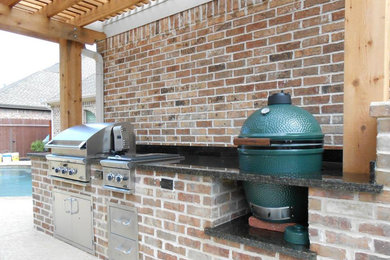Mid-sized elegant backyard patio kitchen photo in Austin with a pergola