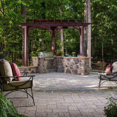 Inspiration for a mid-sized timeless backyard concrete paver patio kitchen remodel in Charlotte with a pergola