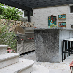 Immagine di un grande patio o portico eclettico dietro casa con pavimentazioni in cemento e una pergola