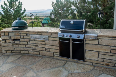 Patio kitchen - large traditional backyard stone patio kitchen idea in Denver