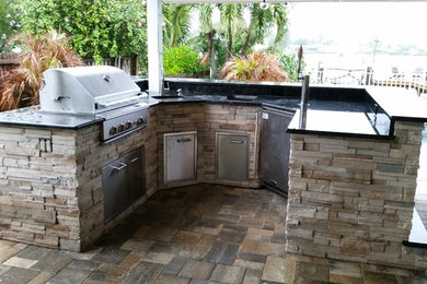 Photo of a medium sized traditional back patio in Tampa with an outdoor kitchen and tiled flooring.