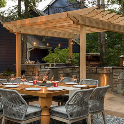 Inspiration for a mid-sized timeless backyard stone patio kitchen remodel in Minneapolis with a pergola