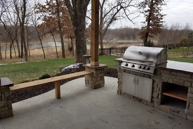 Cette image montre une terrasse arrière chalet de taille moyenne avec une cuisine d'été et une dalle de béton.