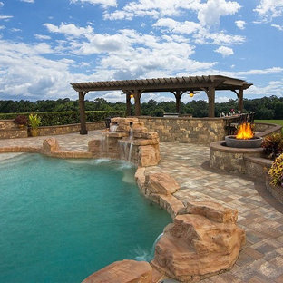 Ispirazione per un grande patio o portico tradizionale dietro casa con pavimentazioni in cemento e una pergola