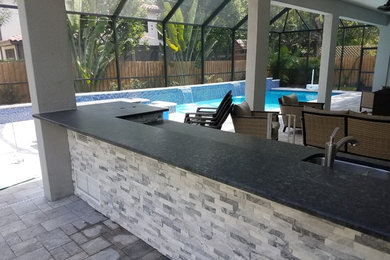 Mid-sized transitional backyard concrete paver patio kitchen photo in Tampa with a roof extension