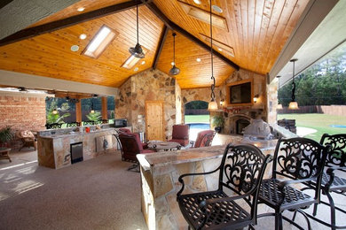 Aménagement d'une terrasse arrière craftsman de taille moyenne avec une cuisine d'été, une extension de toiture et des pavés en pierre naturelle.