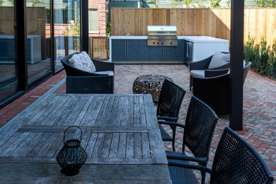 Großer, Überdachter Moderner Patio hinter dem Haus mit Outdoor-Küche und Pflastersteinen in Toronto