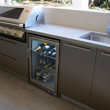 Outdoor Kitchen with a polished concrete benchtop & stainless steel doors.