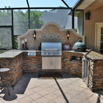 Outdoor kitchen with Big Green Egg, gas grill and bar seating.