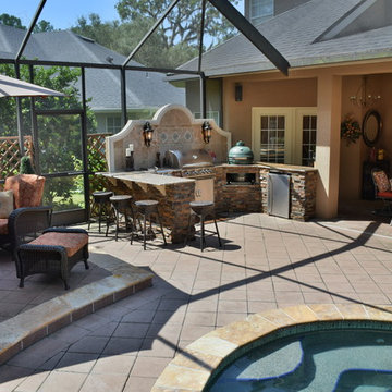 Outdoor kitchen with Big Green Egg, gas grill and bar seating.
