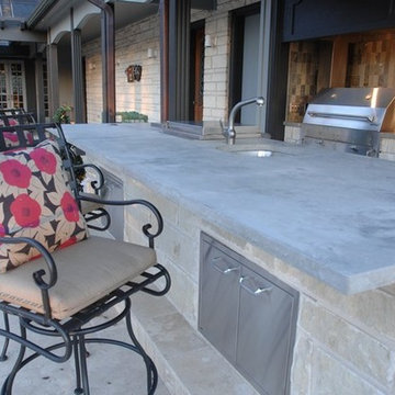 Outdoor Kitchen with Clean Concrete Countertops with Charcoal and Gas Grills