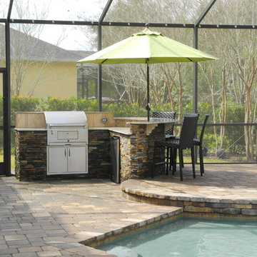 Outdoor Kitchen with curved bar and charcoal grill.