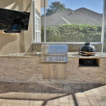 Outdoor kitchen with extended roof and screen enclosure