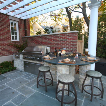 Outdoor kitchen with pergola and stone patio