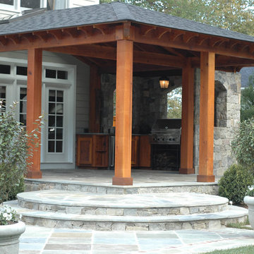 Outdoor Kitchen with Stone Walls and Patio Beneath Cedar Pergola