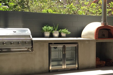 На фото: двор среднего размера на заднем дворе в стиле модернизм с летней кухней и покрытием из бетонных плит без защиты от солнца