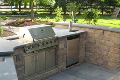 Photo of a back patio in Philadelphia with a fire feature and brick paving.