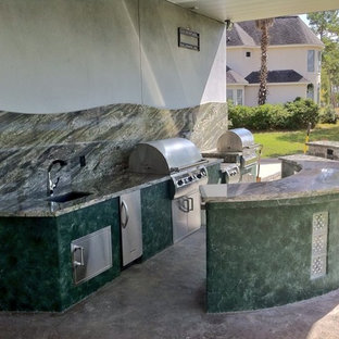 Ispirazione per un patio o portico boho chic dietro casa con cemento stampato e un tetto a sbalzo