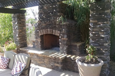 Example of a mid-sized minimalist backyard concrete patio design in Phoenix with a fire pit and a pergola