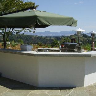 Idee per un ampio patio o portico boho chic dietro casa con pavimentazioni in pietra naturale e nessuna copertura