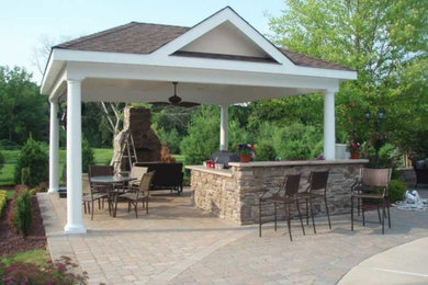 Example of a large classic backyard brick patio kitchen design in New York with a gazebo
