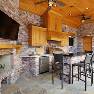 Ispirazione per un patio o portico stile americano di medie dimensioni e dietro casa con cemento stampato e un tetto a sbalzo